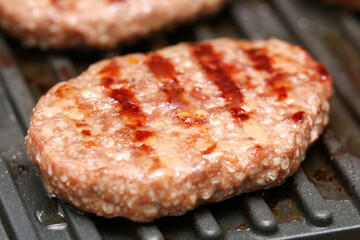 Electric grilled cutlets. Close up beef or pork meat barbecue burgers for hamburger prepared...