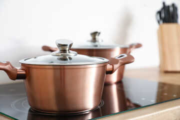 Copper cooking pot on stove in kitchen, closeup
