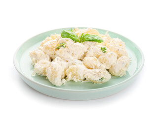 Plate of delicious gnocchi with creamy sauce on white background