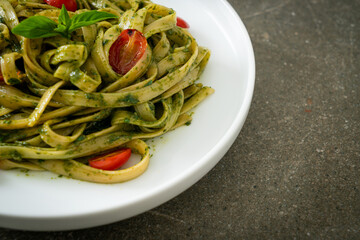 fettuccine spaghetti pasta with pesto sauce and tomatoes