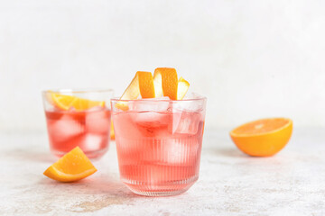 Glasses of tasty Negroni cocktail on light background