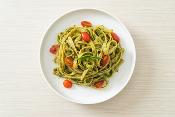 fettuccine spaghetti pasta with pesto sauce and tomatoes