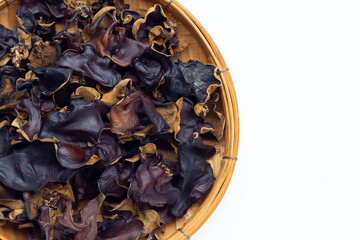 Dried black fungus in bamboo basket on white background.