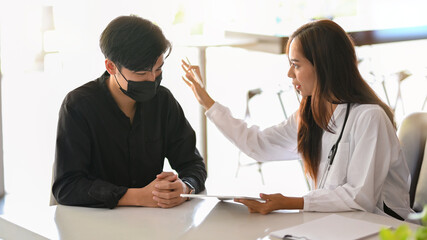 Fototapeta premium Female doctor comforts and supports male patient