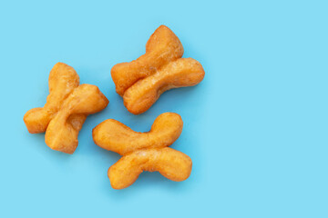Deep-fried dough sticks or chinese bread sticks on blue background.