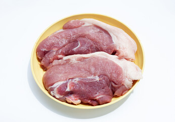 Pork meat in yellow plate on white background.
