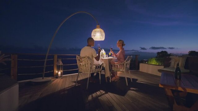 Couple enjoying diner during perfect twilight outdoor setting with ocean view