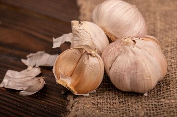 Heads of young garlic on a table covered with burlap, close-up, selective focus.