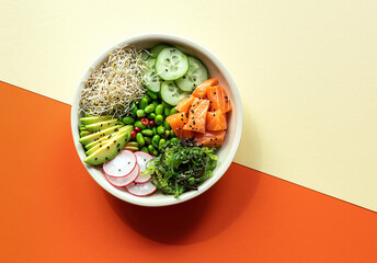 Asian trendy food, sushi poke bowl with edamame beans, cucumber, salmon, avocado, black and white...