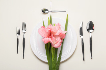 Gorgeous gladiolus flowers and table setting on light background