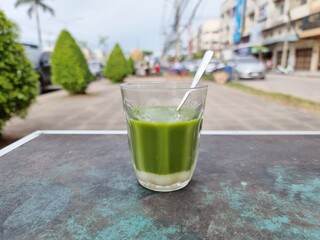 Hot green tea with sugar or sweetened condensed milk on the table, street stalls in Thailand