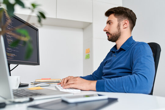 Young man programming writing code working at office