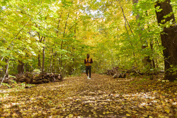 Fototapeta premium Male student walking in the park in autumn season