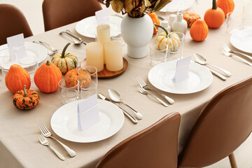 Beautiful autumn table setting with pumpkins and candles at restaurant