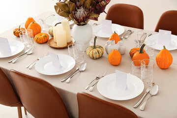 Beautiful autumn table setting with pumpkins and candles at restaurant