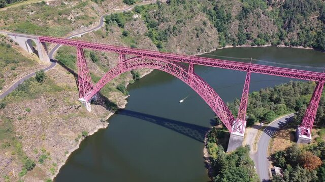 Scenic drone view of parabolic arched framework of railway bridge Viaduc de Garabit across river Truyere near Ruynes-en-Margeride in Auvergne, France