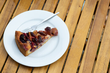 Plum cake on a wooden table with copy space