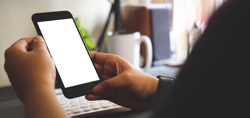 Close up view young woman holding smart phone with white screen.