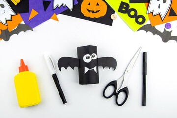 Craft with a child for Halloween from rolls of toilet paper and a black paper bat. Step-by-step instruction summary.