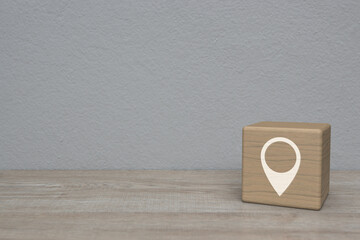 Map pin point location icon on block cube on wooden table over white wall background, Map pointer...
