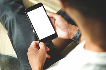 Over the shoulder view of man using smart phone. Blank screen for your information.