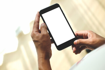 Man holding smart phone with blank display while sitting in living room.