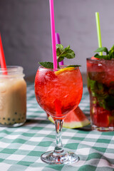 Water melon cocktails and fresh melon, on a table with green plaid tablecloth. Summer drink, cold beverage