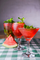 Water melon cocktails and fresh melon, on a table with green plaid tablecloth. Summer drink, cold beverage