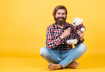 friendship concept. brutal mature hipster man play with toy. happy birthday. being in good mood. happy valentines day. cheerful bearded man hold teddy bear. male feel playful with bear. copy space