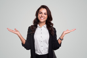 Cheerful businesswoman pointing aside and looking at camera