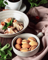Walnut shaped cookies with caramel and walnuts Georgian cookies Oreshki served in a traditional bowl with cup of coffee