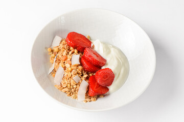 Bowl of hot oatmeal with fresh strawberries cut. Perfect as a healthy breakfast. Served with sour cream in a white bowl.