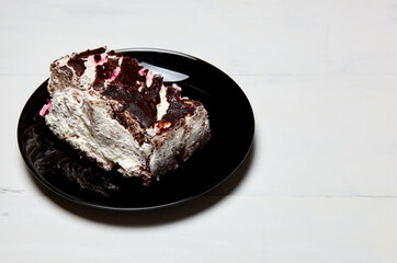 Plate with slice of tasty chocolate cake on table. Yummy dessert on on wooden background, closeup