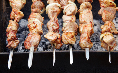 Marinated shashlik preparing on a barbecue grill over charcoal. Traditional Russian shashlik on a barbecue skewer