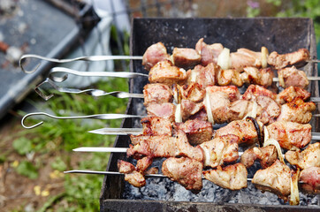 Marinated shashlik preparing on a barbecue grill over charcoal. Traditional Russian shashlik on a barbecue skewer