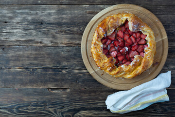 tart with strawberries on a wooden table. Copy space, top view.