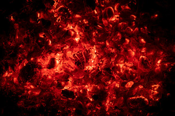 Red glowing charcoal in a campfire against