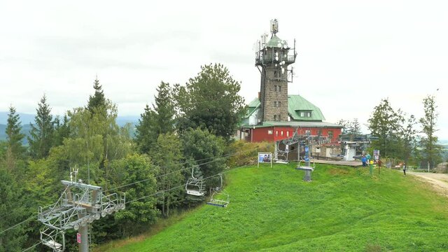 Mountain with lookout tower at summit. Chair lift brings bikes and bikers.  Popular ski resort at summer time, north of Czech Republic.
