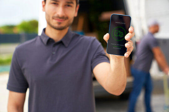 Delivery man showing mobile app on smart phone