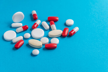  medical background of various tablets, pills, and capsules on a blue surface, top view, copy space, medicine, health, treatment, pharmacy concept