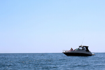 Naklejka na ściany i meble A young girl sunbathes on a yacht moored in the sea.