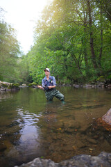 young woman fly fishing in a mountain river