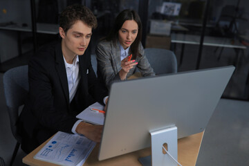 Two business people working together on computer.
