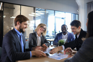 startup business team on meeting in modern bright office interior brainstorming, working on laptop and tablet computer.