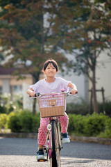 Obraz premium 真夏の公園で自転車を乗って遊んでいる子供の姿