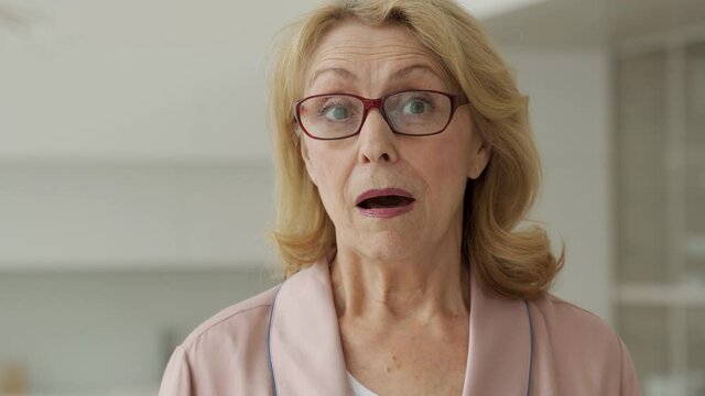 Stylish, elderly surprised, shocked woman looking out with her mouth wide open