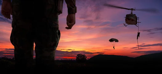 Rugzak Silhouette back side view soldier paarachute and helicopter soldier under army training and big tree at sunset mountain twilight sky background. © APchanel