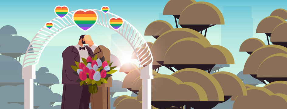 newlywed gay couple with flowers kissing near wedding arch transgender love LGBT community wedding celebration