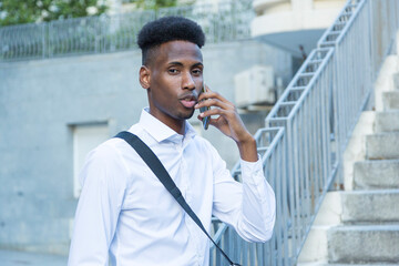 portrait young african american business man on stairs talking on mobile phone