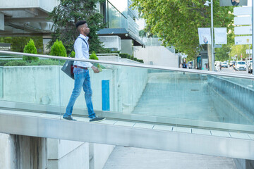 young black business man walking on a glass bridge connected by phone